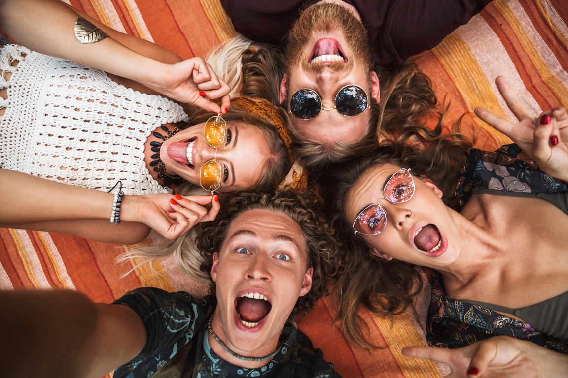Portrait of Happy Hippies People Laughing, and Lying on Blanket